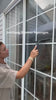 Woman using dancemoon JustHang squeegee to clean windows and glass during an everyday cleaning routine