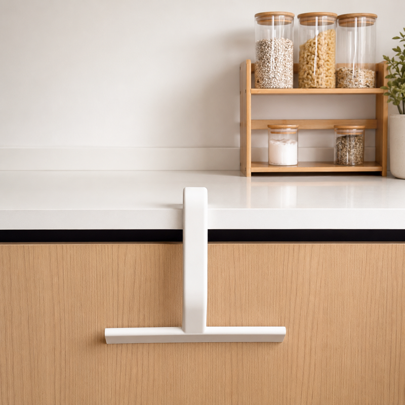 White JustHang squeegee hanging from a kitchen countertop by its built-in hook